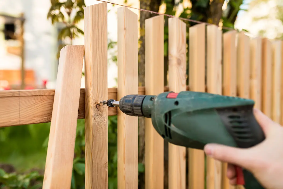 A-gardener-repairing-a-wooden-fence-in-a-garden